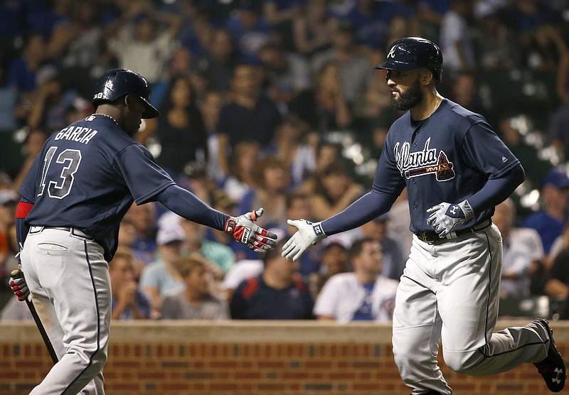 Atlanta Braves' Nick Markakis, right, celebrates with Adonis Garcia after hitting a solo home run against the Chicago Cubs during the ninth inning of a baseball game Thursday, July 7, 2016, in Chicago.