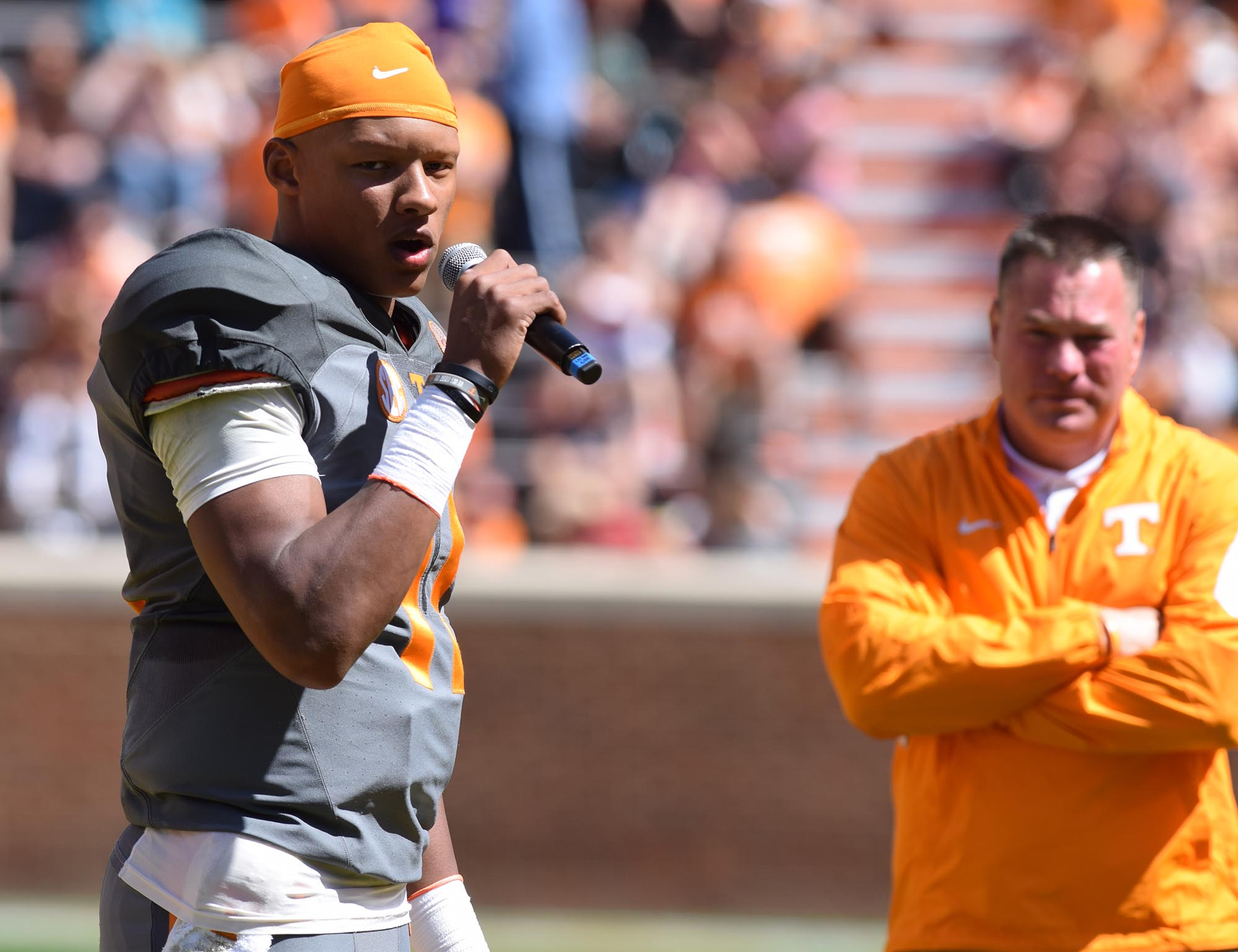 Quarterback Joshua Dobbs (11) talks to the crowd about being named a captain while head coach Butch Jones looks on.  The University of Tennessee Orange/White Spring Football Game was held at Neyland Stadium in Knoxville on April 16, 2016.