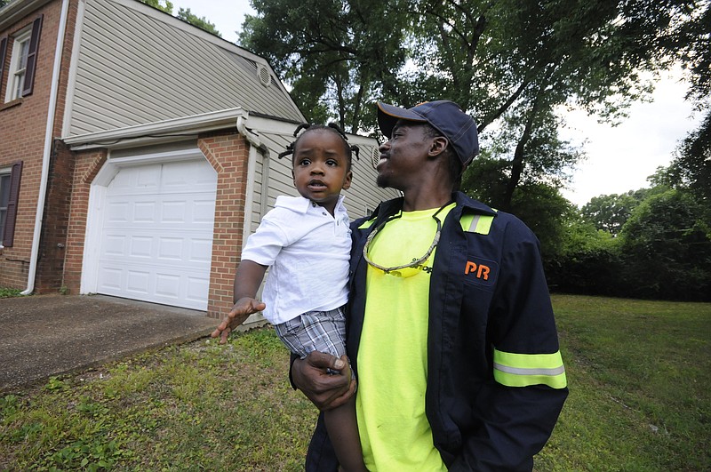 Upon arriving to his East Ridge residence, Jimmie Lebron Williams greets his son, Kaptain Levi Williams, 1, right after work last week. 