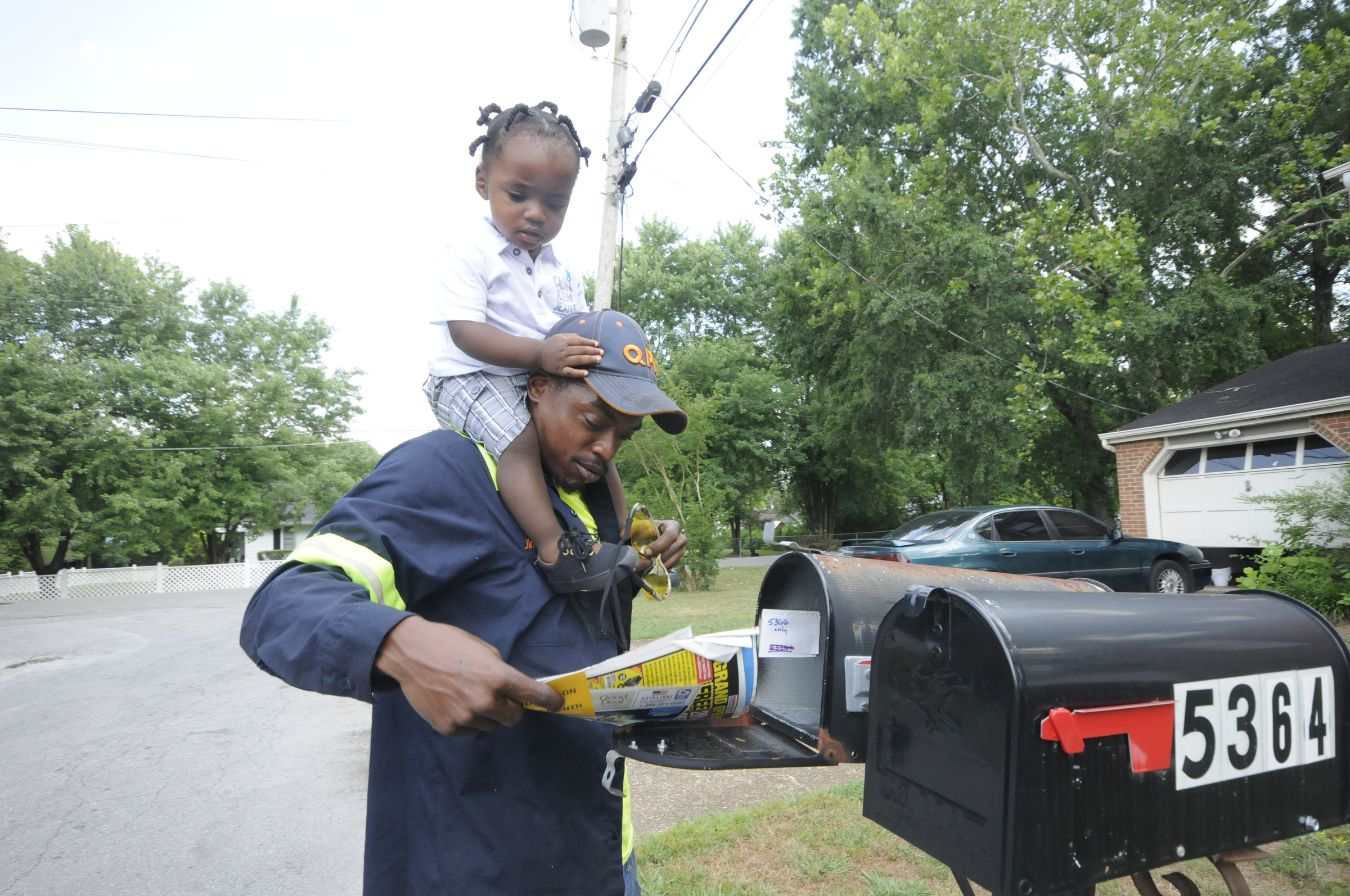 Upon arriving to his East Ridge residence, Jimmie Lebron Williams checks the mail with his son, Kaptain Levi Williams, 1, aboard after work last week.