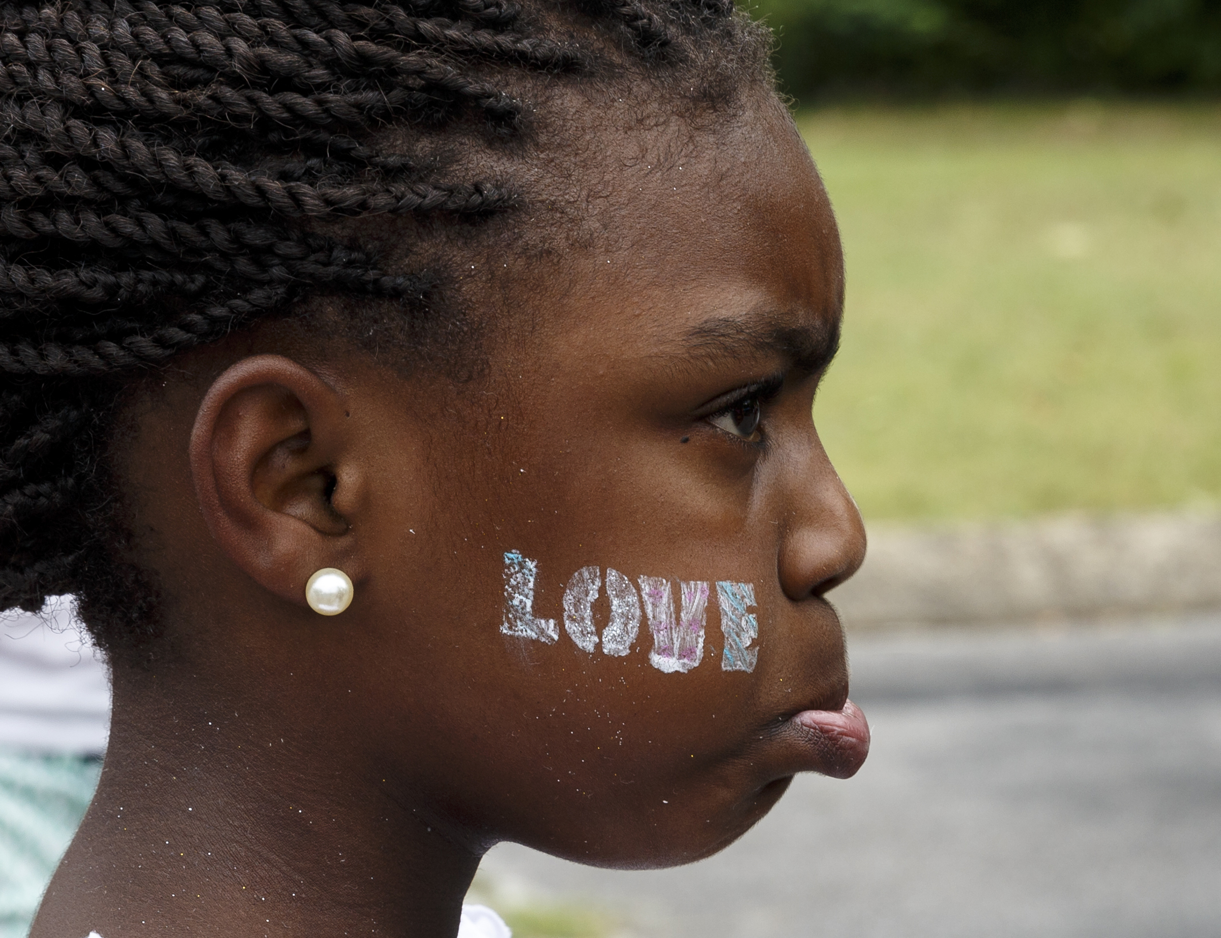 Raynaria Clark watches rapper Tru Saint perform at a block party and fundraiser at Westside Baptist Church held to raise money for community projects to make Alton Park a better place to live on Saturday, July 9, 2016, in Chattanooga, Tenn. The fundraiser, organized by Westside Baptist Church and the Nation of Islam, was held to assist in the establishment of the Community Haven which will include a nutrition and healthy eating program, counseling, and other services.
