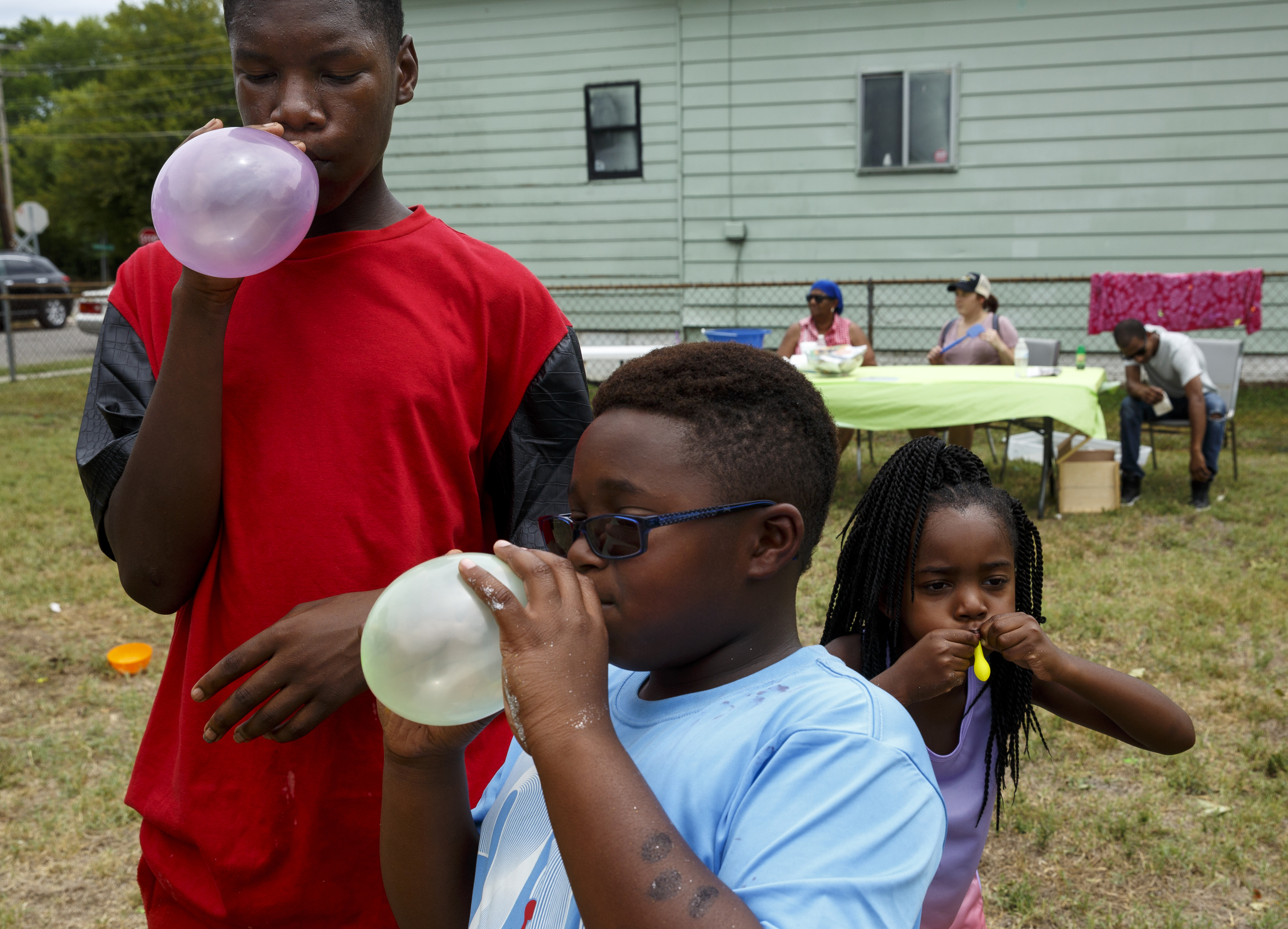 Tareef Binford, Ari Craig, and Janiyah Jackson, from left, blow up balloons at a block party and fundraiser at Westside Baptist Church held to raise money for community projects to make Alton Park a better place to live on Saturday, July 9, 2016, in Chattanooga, Tenn. The fundraiser, organized by Westside Baptist Church and the Nation of Islam, was held to assist in the establishment of the Community Haven which will include a nutrition and healthy eating program, counseling, and other services.