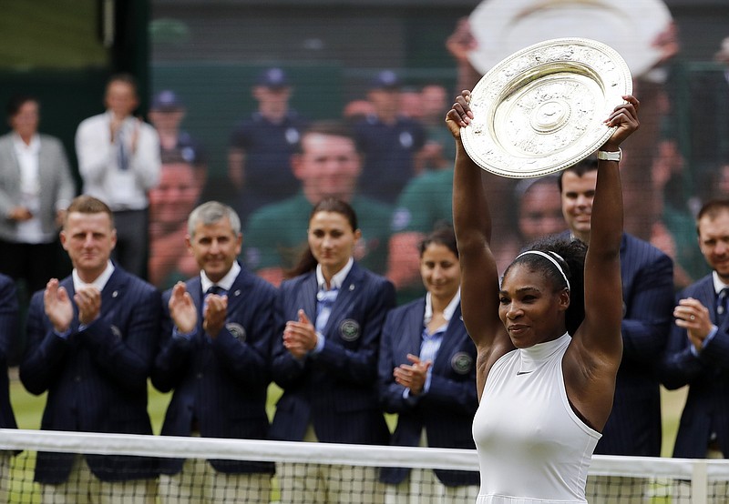 Serena Williams of the U.S raises the trophy after beating Angelique Kerber of Germany in the women's singles final on day thirteen of the Wimbledon Tennis Championships in London, Saturday, July 9, 2016.