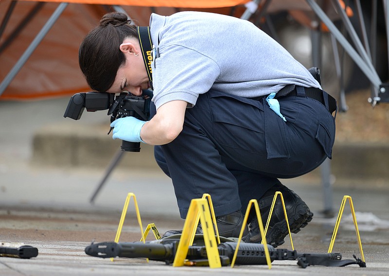 A law enforcement agent photographs the scene of a multiple shooting in Bristol, Tenn., on Thursday, July 7, 2016. Police say multiple people have been injured and one person was taken into custody after a man opened fire on motorists traveling along a parkway in East Tennessee. Bristol police say the incident happened early Thursday in the city along the Virginia border.