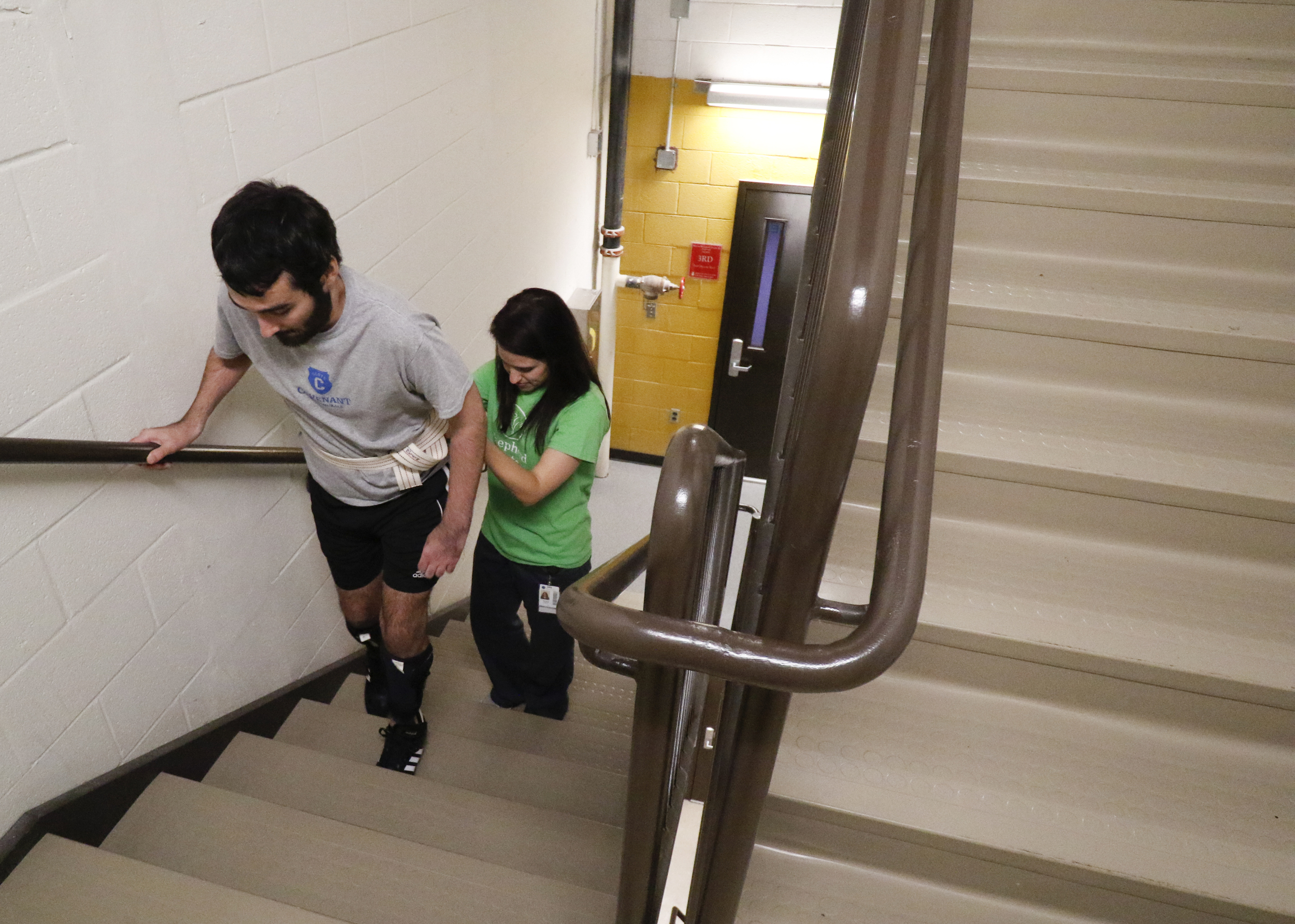 Staff Photo by Dan Henry / The Chattanooga Times Free Press- 6/27/16. Rachel Mahon, a physical therapist at the Shepherd Center, guides Joel Elmore as he ascends two flights of stairs while at the rehabilitation center in Atlanta, Ga., on Monday, June 27, 2016. Elmore, a 22-year-old, contracted Guillain-Barre Syndrome in his senior year of college and was totally immobilized but is now going through physical rehab at Shepherd.