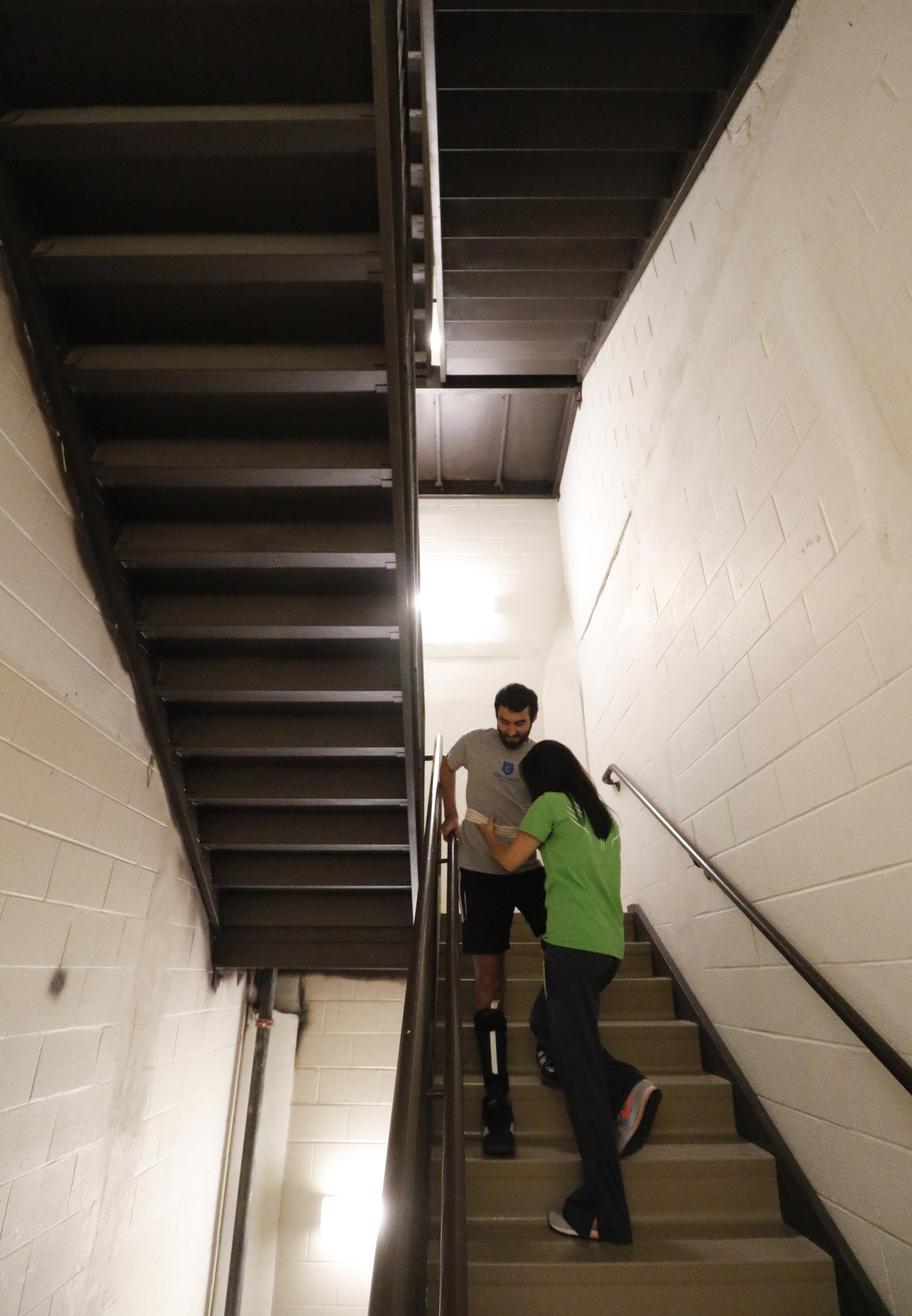Staff Photo by Dan Henry / The Chattanooga Times Free Press- 6/27/16. Rachel Mahon, a physical therapist at the Shepherd Center, guides Joel Elmore as he descends two flights of stairs while at the rehabilitation center in Atlanta, Ga., on Monday, June 27, 2016. Elmore, a 22-year-old, contracted Guillain-Barre Syndrome in his senior year of college and was totally immobilized but is now going through physical rehab at Shepherd.