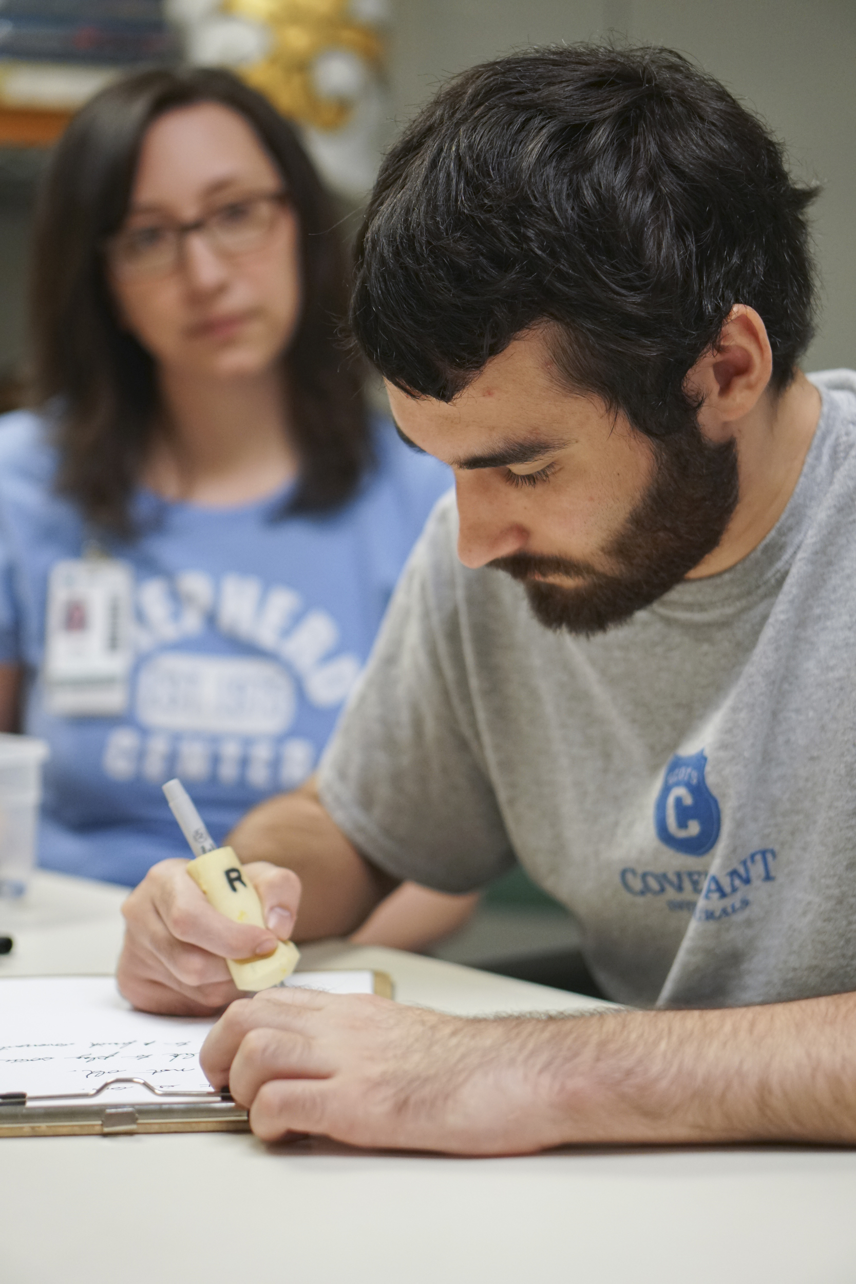 Staff Photo by Dan Henry / The Chattanooga Times Free Press- 6/27/16. Sara Brockman, an occupational therapist at the Shepherd Center, watches as Joel Elmore works to regain hand dexterity and writing skills while at the rehabilitation center in Atlanta, Ga., on Monday, June 27, 2016. Elmore, a 22-year-old, contracted Guillain-Barre Syndrome in his senior year of college and was totally immobilized but is now going through physical rehab at Shepherd.