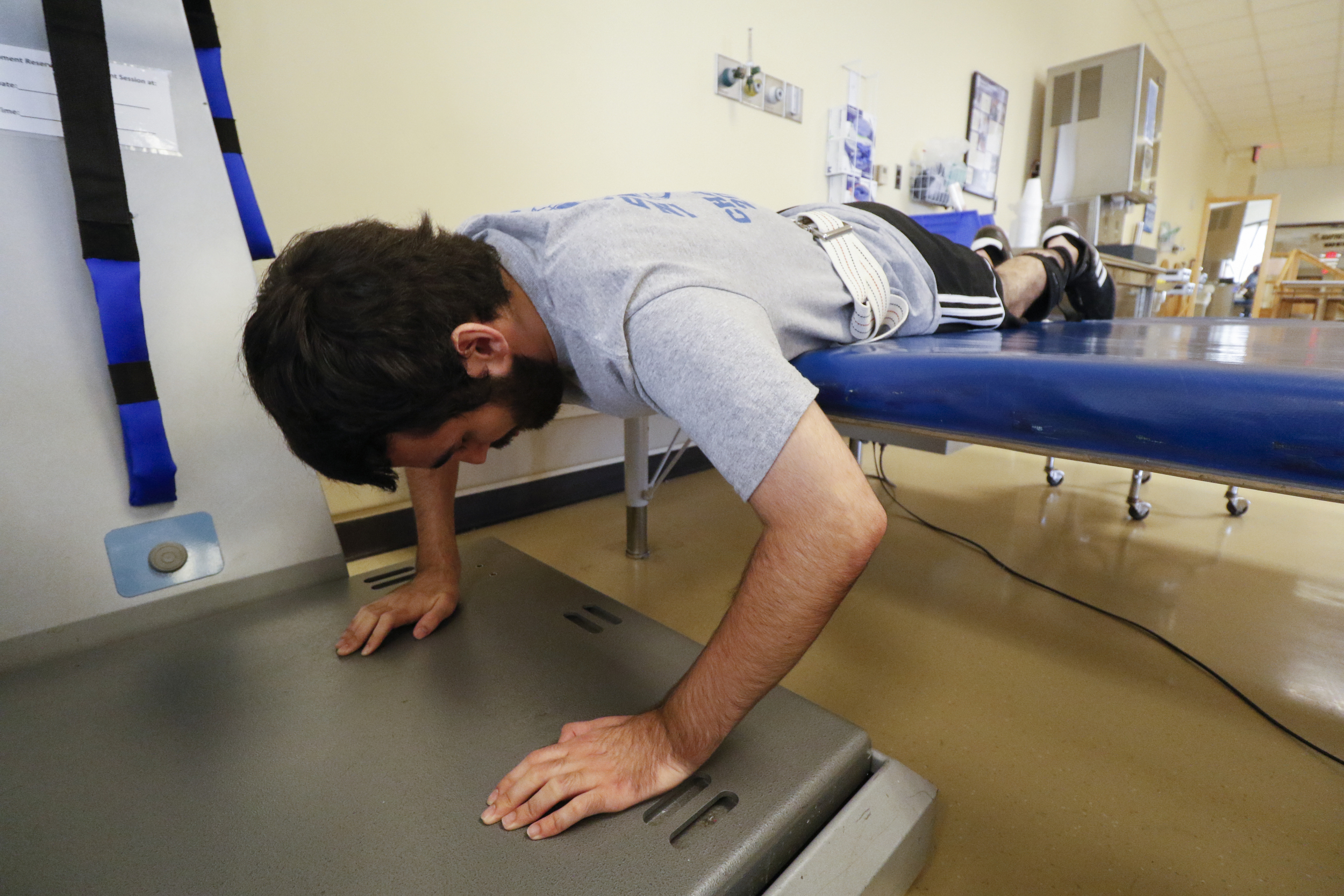 Staff Photo by Dan Henry / The Chattanooga Times Free Press- 6/27/16. Joel Elmore performs pushups on a WAVE machine to help him regain core strength and muscle dexterity while at the rehabilitation center in Atlanta, Ga., on Monday, June 27, 2016. Elmore, a 22-year-old, contracted Guillain-Barre Syndrome in his senior year of college and was totally immobilized but is now going through physical rehab at Shepherd.