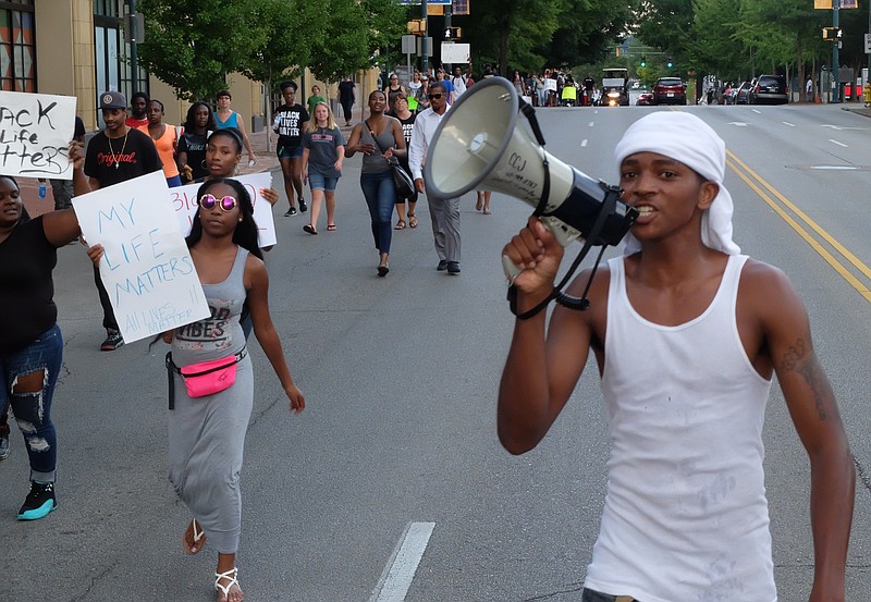 David Mobley calls out to participants in a march to end violence on M.L. King Blvd. late Sunday. The march began and ended at Coolidge Park on the Northshore in downtown Chattanooga. Participants walked for more than two hours beginning at 6 p.m., making the loop across the Tennessee River to downtown and back across ending at 8:25 p.m.