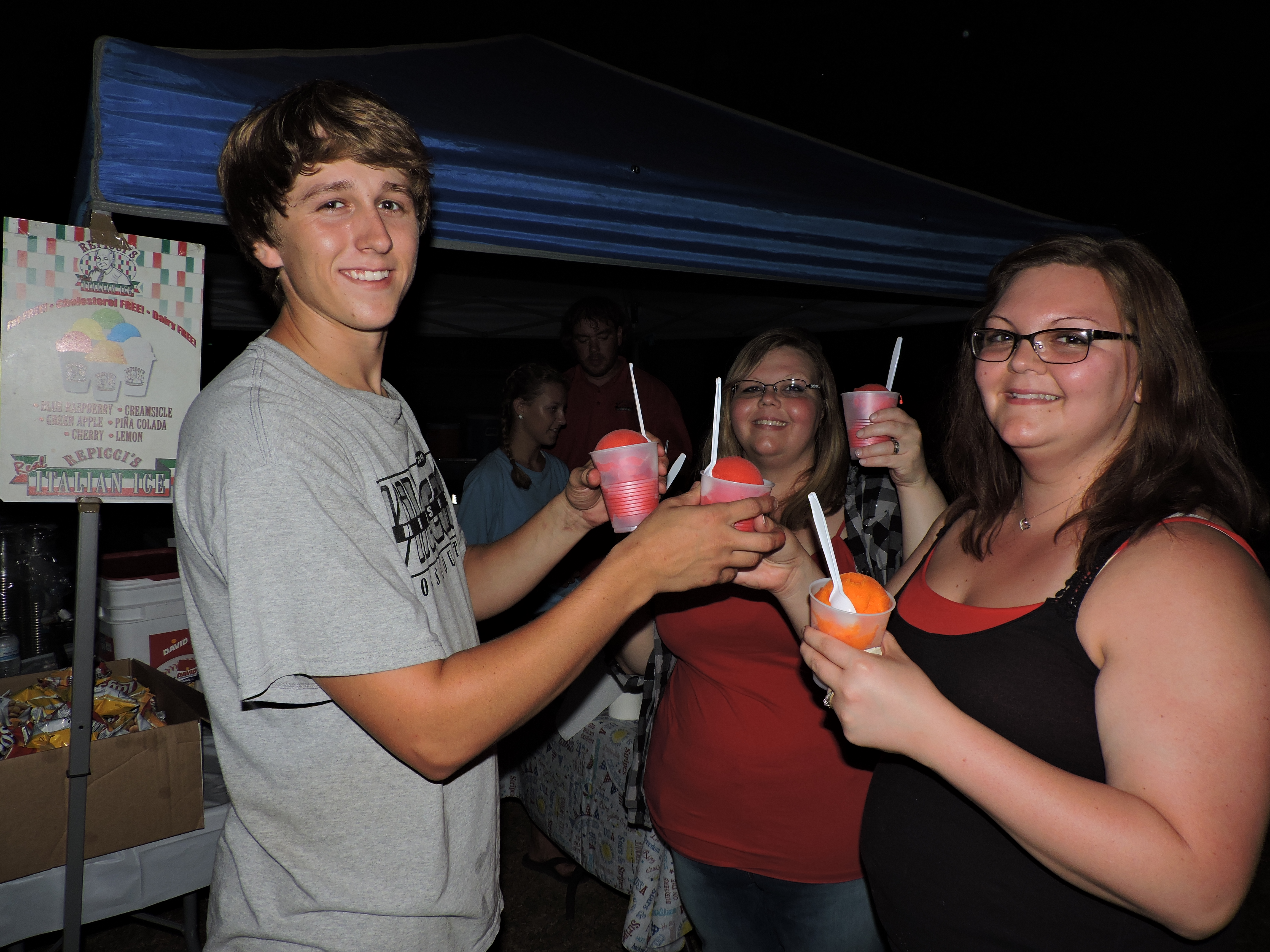 Attendees stop by the Repicci's Italian Ice booth for a cool treat. From left are server Chandler Abbott, and sisters Mindy Delashmitt, of Hixson, and Olivia Delashmitt, of Chattanooga.