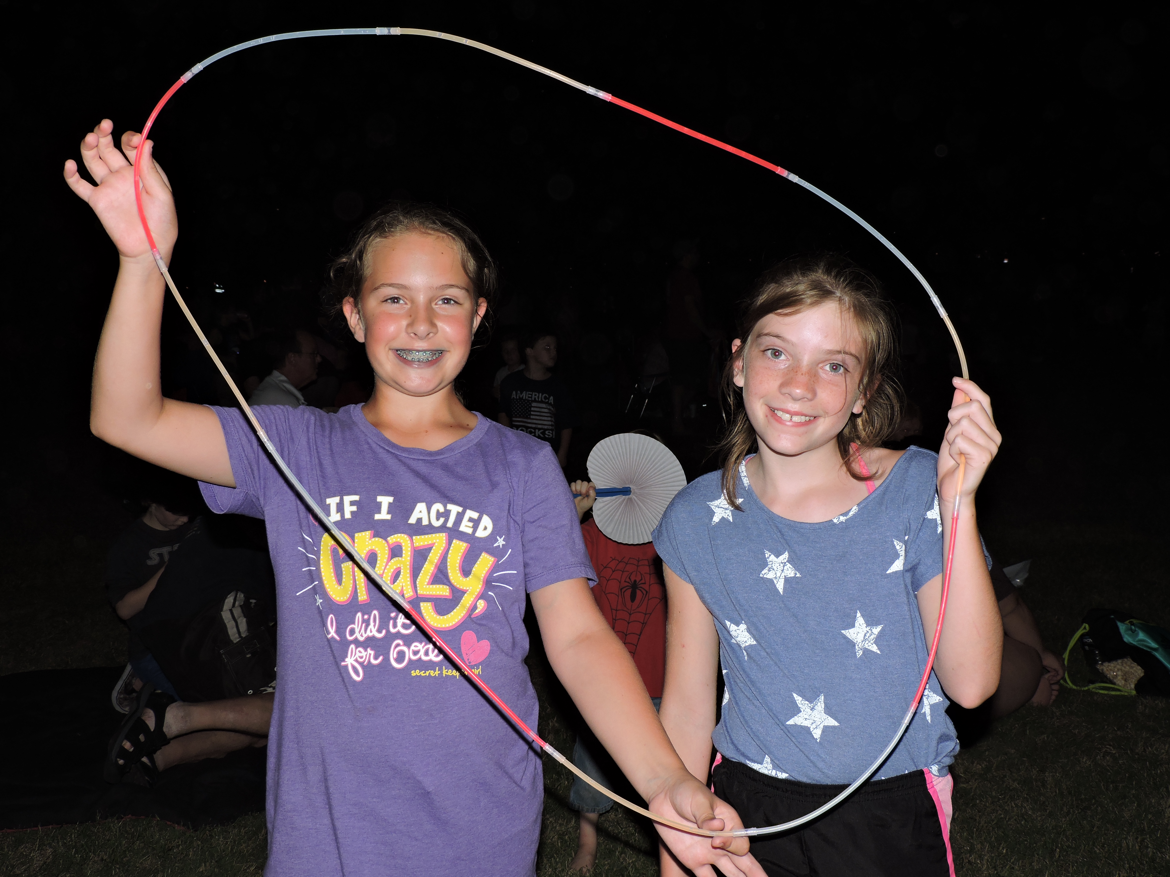 Frances Lewis, 11, of Fairview, left, and Jordan Andrews, 10, of Chattanooga, make their own fun by connecting glow necklaces together to create a big hoop to play with.