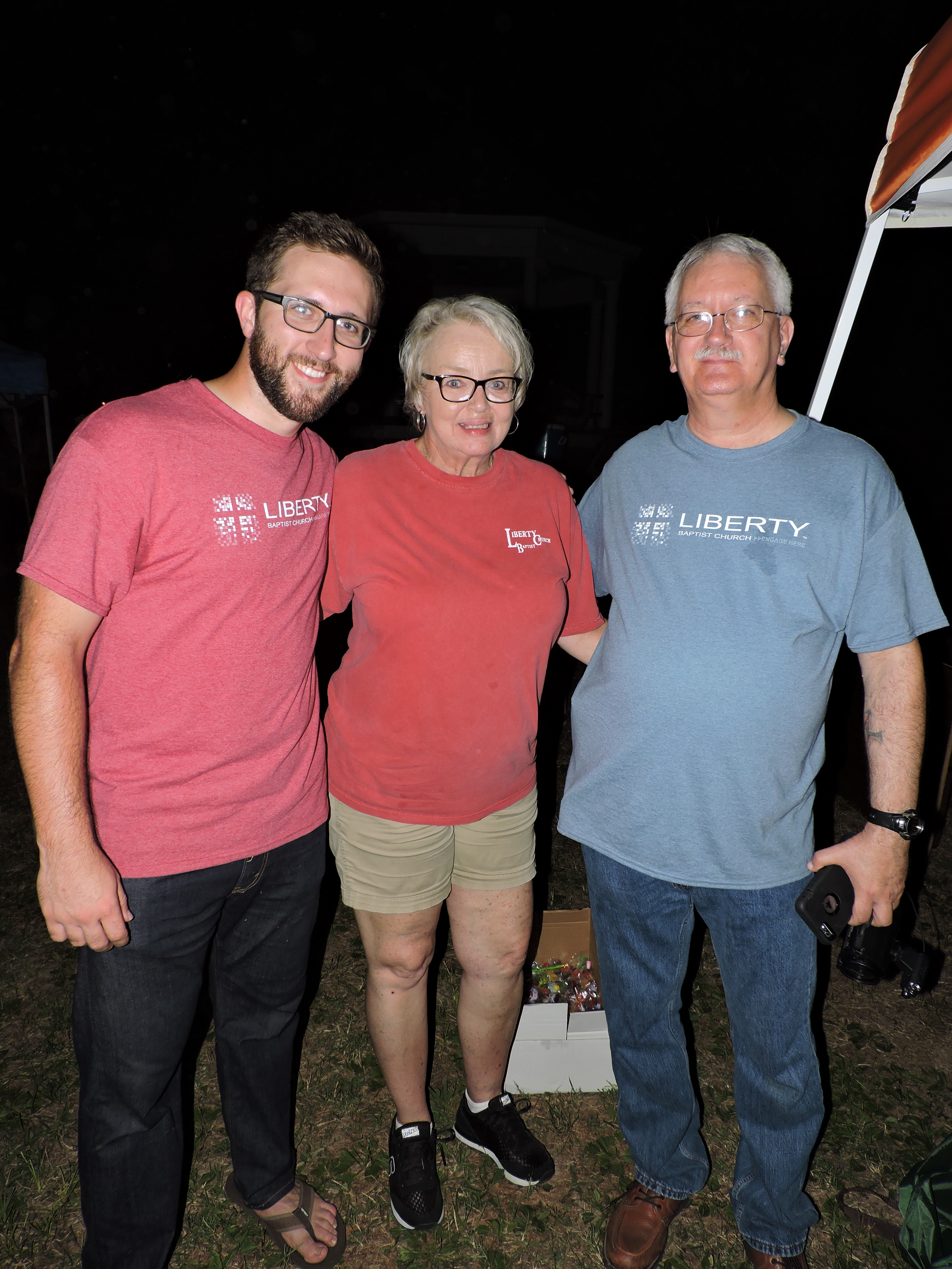 Liberty Baptist Church Fort Oglethorpe campus pastor Ryan Ralston and volunteers Jerene Jones and Tom McDaniel, from left, talk to spectators on the Polo Field beside Barnhardt Circle.