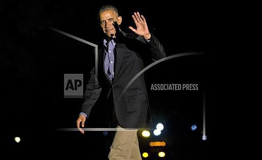 President Barack Obama waves on his return from a shortened visit to Spain, as he walks across the South Lawn of the White House in Washington, Sunday, July 10, 2016. (AP Photo/Jacquelyn Martin)