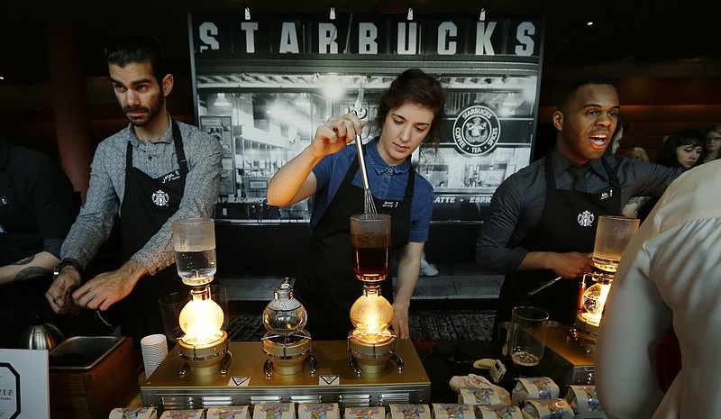 
              FILE - In this Wednesday, March 23, 2016, file photo, Starbucks workers prepare coffee using siphon vacuum coffee makers at a station in the lobby of the coffee company's annual shareholders meeting in Seattle. Starbucks says that it will be boosting the base pay of all employees and store managers at U.S. company-run stores by 5 percent or more on Oct. 3. In a letter sent to workers on Monday, July 11, 2016, CEO Howard Schultz said that the amount of the raise will be determined by geographic and market factors. (AP Photo/Ted S. Warren, File)
            