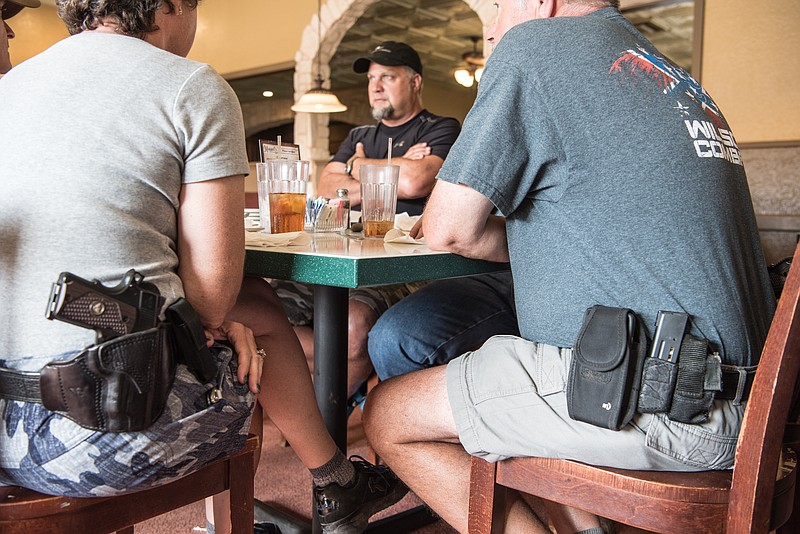 
              Jeff Coursey, of Paris Texas, center, sits in a restaurant on Saturday, July 9, 2016. Coursey is considering starting a local chapter of Open Carry Texas, which supports the right to openly carry a firearm in public. Seated at the table with him are Bill Wilson, owner of Wilson Combat, an Arkansas gunmaker, and his wife, Joyce Wilson, executive director of International Defensive Pistol Association. (AP Photo/Lisa Marie Pane)
            