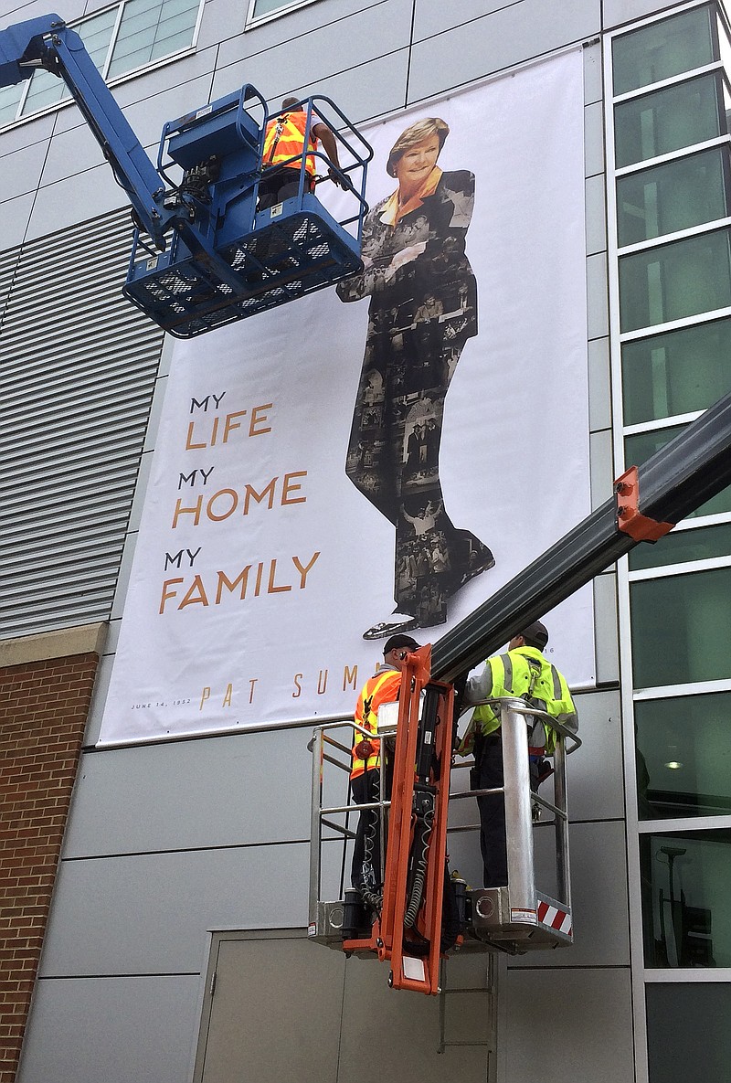 
              Workers replace a banner honoring the late Pat Summitt, former women's basketball coach at Tennessee, on Monday, July 11, 2016, in Knoxville, Tenn. The original banner was damaged during a recent storm. A celebration of life program honoring Summitt is scheduled to be held at the university's basketball arena Thursday, July 14. (AP Photo/Mark Humphrey)
            