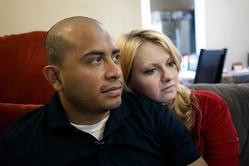 
              Dallas Police Department Officer Jorge Barrientos, left, is pictured recovering at his home with his girlfriend, Bethany Knutson, Sunday, July 10, 2016, in Dallas. Barrientos was shot in the hand and struck by shrapnel when a gunman attacked officers at a protest against police brutality July 7, 2016. He recounted desperately trying to help fellow officers who were shot, including three from his unit who died. (AP Photo/Christine Armario)
            