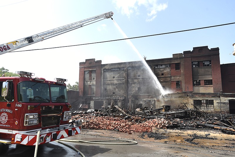 Firefighters spray water over the remains of the old Standard Coosa Thatcher plant Tuesday, July 12, 2016, after a fire destroyed part of the structure early Tuesday morning.