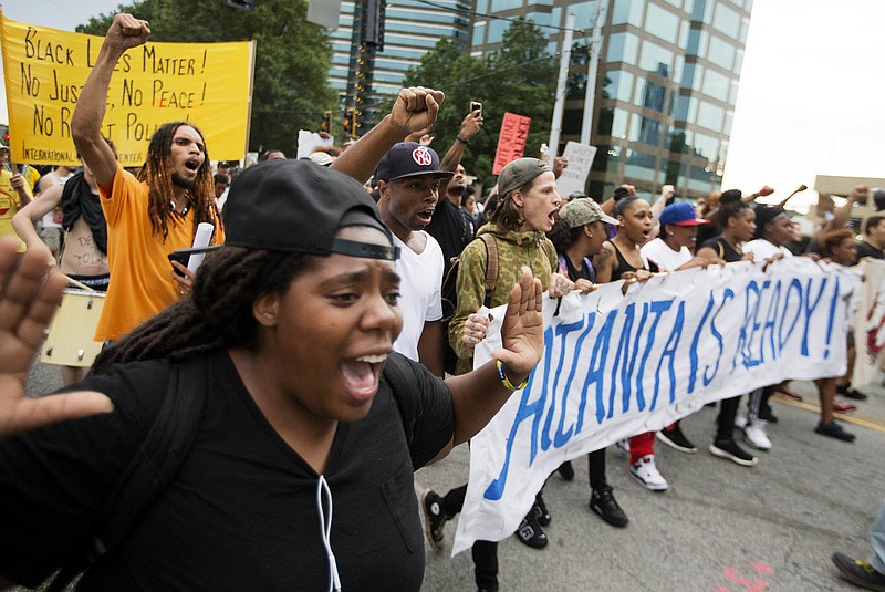 
              Protesters march through an intersection in the Buckhead neighborhood during a demonstration against the recent police shootings of African-Americans on Monday, July 11, 2016, in Atlanta. (AP Photo/David Goldman)
            