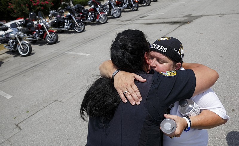 Cathy Wells, mother of Skip Wells, right, hugs Chattanooga Police Officer Christina Henderson at Thunder Creek Harley Davidson after a motorcycle ride from Atlanta to Chattanooga to honor the memory of Skip on Saturday, July 9, 2016, in Chattanooga, Tenn.
