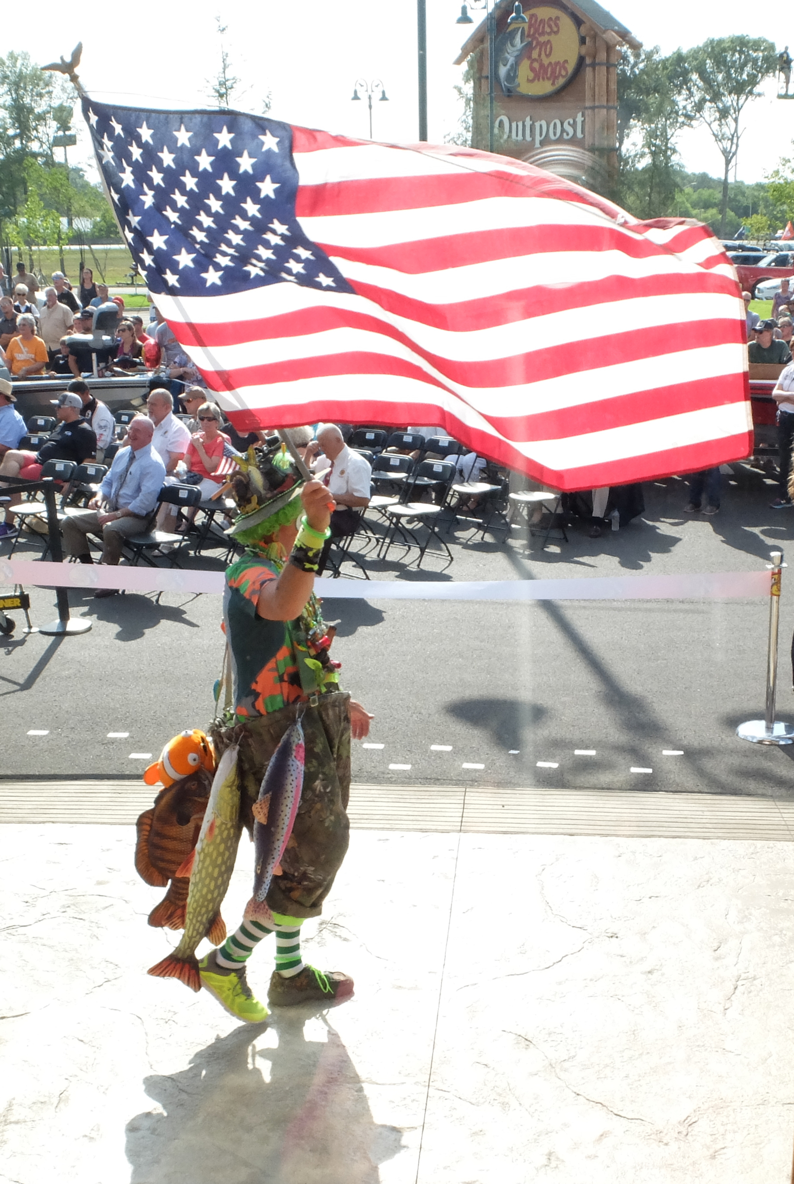 Camo the Clown carries an American flag outside the 85,000-square-foot Bass Pro Shops Outpost during the opening ceremonies in East Ridge late Wednesday.