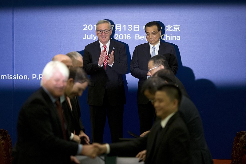 
              Chinese Premier Li Keqiang, center right, and European Commission President Jean-Claude Juncker, center left, applaud during a signing ceremony between Chinese and European Union officials at the Great Hall of the People in Beijing, Wednesday, July 13, 2016. (AP Photo/Ng Han Guan, Pool)
            