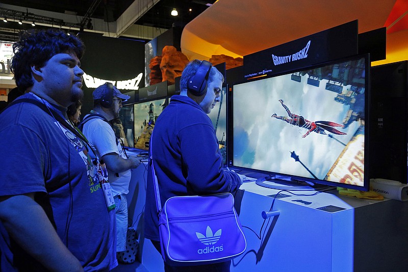 
              FILE - In this June 15, 2016 file photo,  a spectator watches players trying out the PlayStation "Gravity Rush 2" video game at the Electronic Entertainment Expo in Los Angeles. The boost in sales from viewers watching online streaming video isn't merely changing how game makers market and promote their latest creations. It's also reshaping how they design games from the outset. (AP Photo/Nick Ut, File)
            