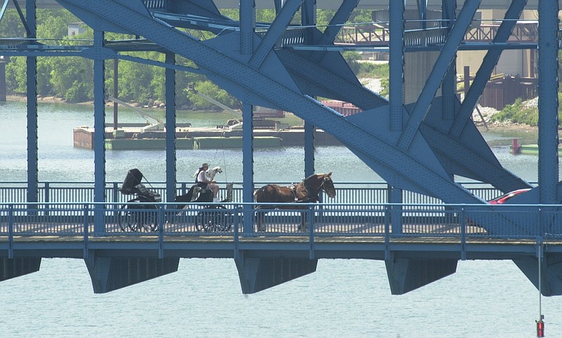 Staff Photo by Chad McClure With a faithful dalmation sitting by her side, the driver of a horse and carriage heads north, crossing the Tennessee River on the Chief John Ross Bridge on a sunny afternoon in 2001.