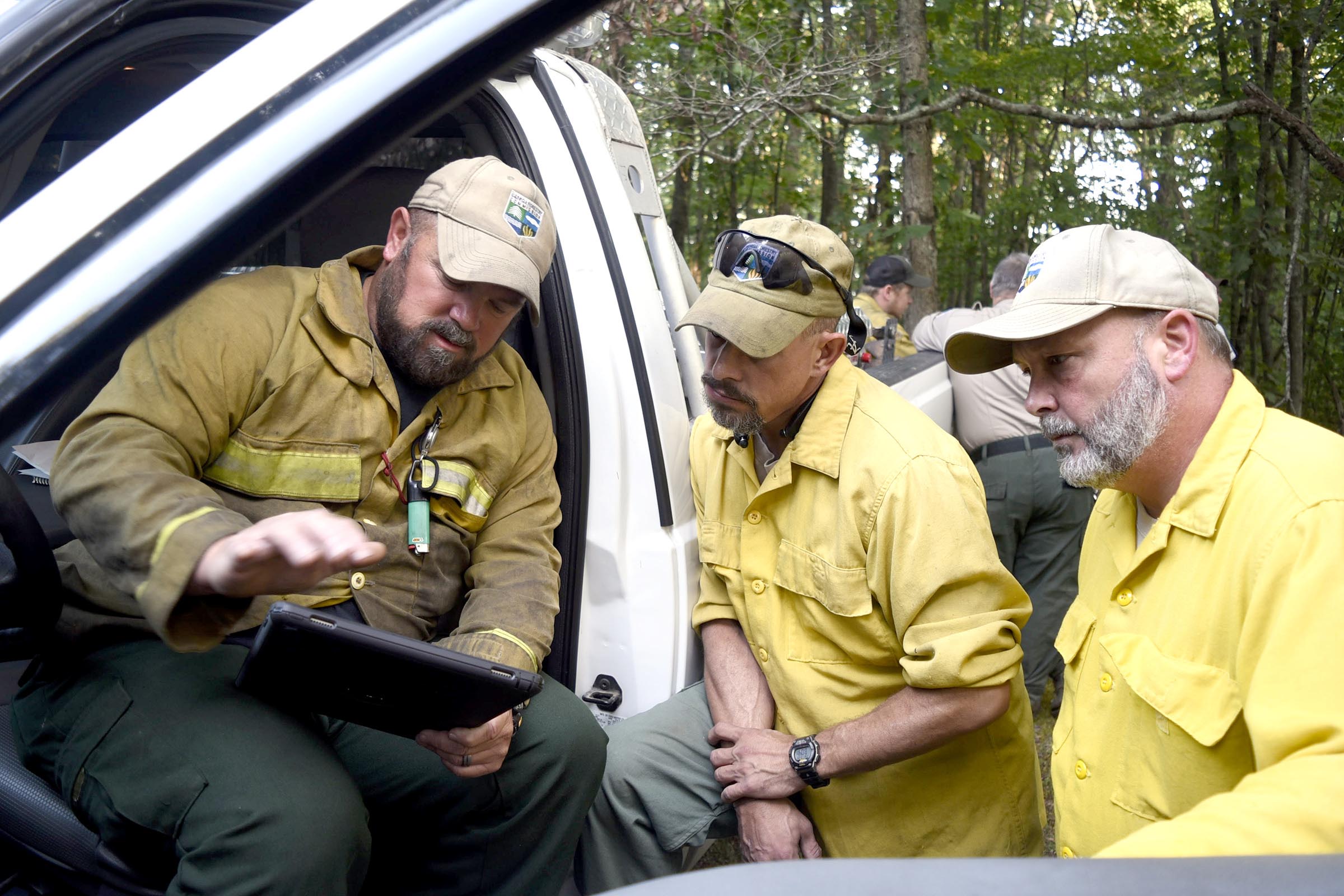 From left, Georgia Forestry Commission Chief Ranger, Heath Morton, discusses the location of the wildfire with fellow Georgia Fostery Commission Rangers, Dean Cornett of Chattooga County, and Brian Rooks of Polk County.  Multiple agencies united to fight a wildfire on the west slope of Lookout Mountain below Covenant College Thursday July 14, 2016.