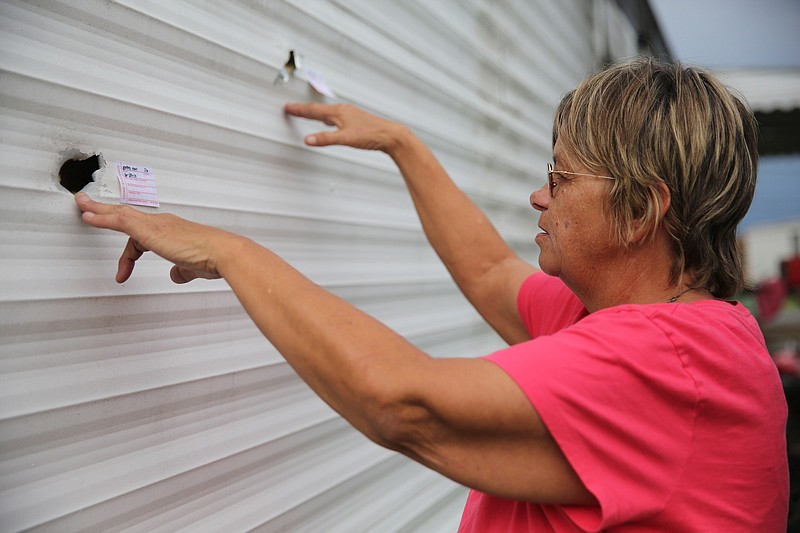 Vickie Penny points out bullet entry holes in her daughter's trailer at Mimosa Trailer Park in Soddy Daisy, Tenn., on Sunday, June 29, 2014. Penny's daughter, Crystal Ostrum, 39, who was recently remarried, was the victim of a shooting this morning.