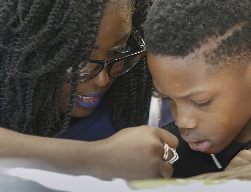 Staff Photo by Dan Henry / The Chattanooga Times Free Press- Fourth grade student Mekel Hill works on new vocabulary with help from Orchard Knob Middle School Language Arts teacher Kelly Greene during a literacy summit for educators at Orchard Knob Elementary School in June.