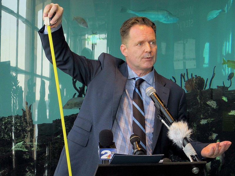 
              Kevin Mills, the president of the South Carolina Aquarium holds up a tape measure at the aquarium in Charleston, S.C., on Thursday, July 14, 2016. Mills was showing what some experts say will be the increase in the local water table during the next century as a result of sea level rise. Mills announced a new initiative to help South Carolina coastal communities prepare for the effects sea level rise with an emphasis on educating Gullah communities on the coastal sea islands. (AP Photo/Bruce Smith)
            