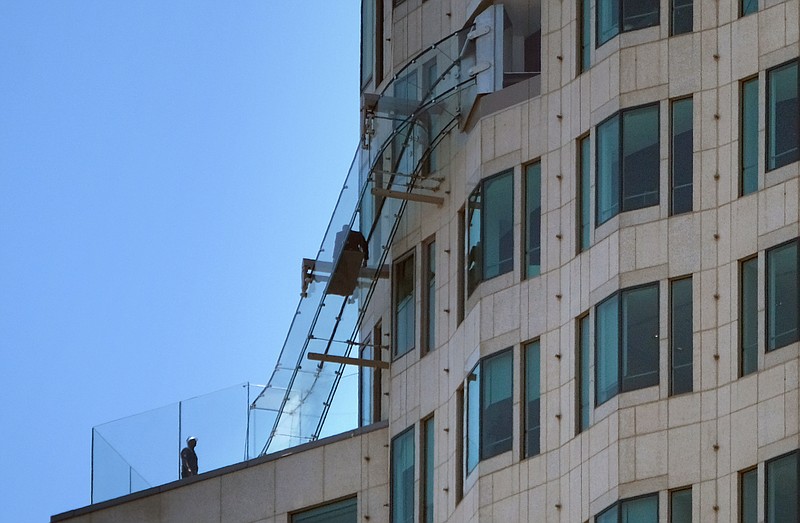 
              FILE - This Wednesday, June 22, 2016 file photo shows a man rides down a glass slide on the U.S. Bank Tower in downtown Los Angeles. A lawsuit claims a woman suffered a broken ankle on the recently opened glass-enclosed slide attached to the exterior of a downtown Los Angeles skyscraper. The lawsuit filed Wednesday, July 13, 2016, against building owner OUE Skyspace LLC and a concession company claims negligence. (AP Photo/Richard Vogel,File)
            