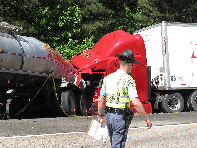 
              FILE - In this April 22, 2015 file photo, a Georgia state trooper works the scene of a deadly crash in Ellabelle, Ga., west of Savannah.   A hearing for John Wayne Johnson was scheduled for Thursday, July 14, 2016 in Bryan County Superior Court.  Johnson, a truck driver from Shreveport, La., was indicted last month by a grand jury on criminal charges including five counts of first-degree vehicular homicide. The charges stem from the April 2015 crash on Interstate 16 west of Savannah that killed five nursing students from Georgia Southern University. Johnson was behind the wheel of a tractor-trailer that slammed into stop-and-go traffic stalled by an unrelated wreck.(AP Photo/Russ Bynum)
            