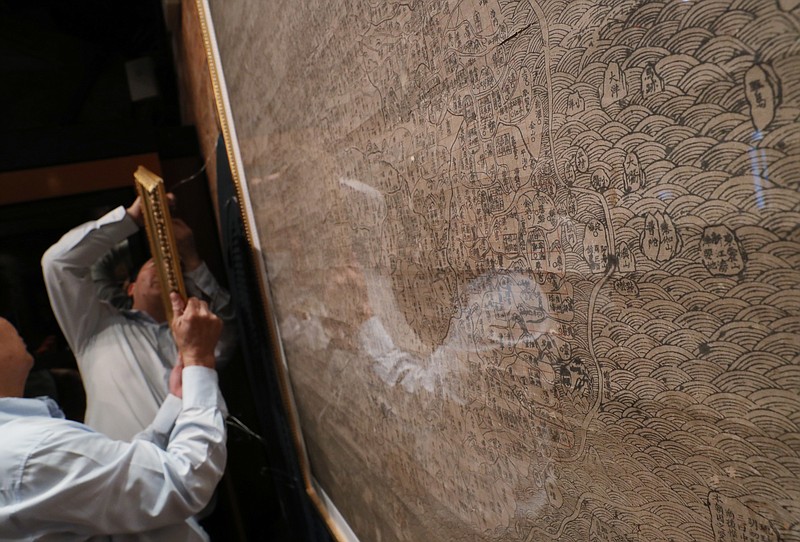 
              Staff hang up copies of maps dating from the Qing Dynasty purporting to back up China's claims to vast parts of the South China Sea, in Hong Kong Thursday, July. 14, 2016. An international tribunal ruled in favor of the Philippines this week saying that China had no basis for expanses claims in the sea. (AP Photo/Kin Cheung)
            