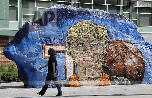 A pedestrian passes a painting of former Tennessee women's basketball coach Pat Summitt on The Rock on the Tennessee campus Thursday, July 14, 2016, in Knoxville, Tenn. The Rock is a school landmark that is regularly painted by students. A ceremony to celebrate the life of Summitt is scheduled for Thursday evening in the university's basketball arena. Summitt died June 28 at the age of 64. (AP Photo/Mark Humphrey)