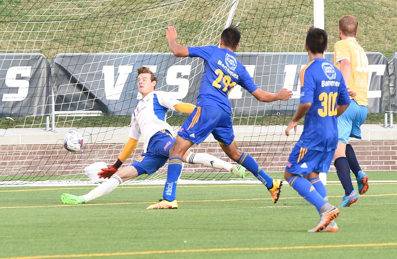 Tigres' goal keeper Miguel Ortega stretches, but misses the goal by John "Snoopy" Davidson, far right, in first half action Thursday at Finley Stadium.