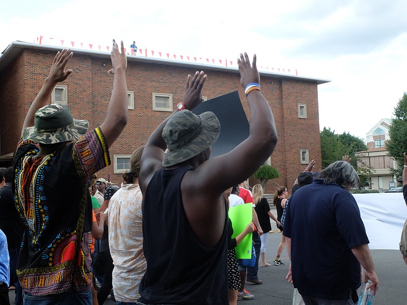 March for Justice participants walk with hands up on their way to the Courthouse in downtown Dalton late Friday.