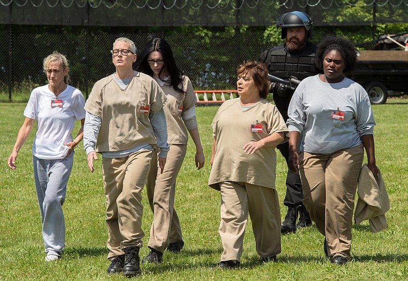 
              In this image released by Netflix, Constance Shulman, from left, Lori Petty, Laura Prepon, Brad William Henke, background,  and Danielle Brooks, right, appear in a scene from, "Orange is the New Black." Veterans’ groups are disturbed by the way veterans are portrayed in the new season of the Netflix series.  In the fourth season of the comedy-drama about a women’s prison, military veterans have been hired as guards. The veterans’ groups take issue with the way the new guards disparage the inmates and talk about their combat experiences. (JoJo Whilden/Netflix via AP)
            