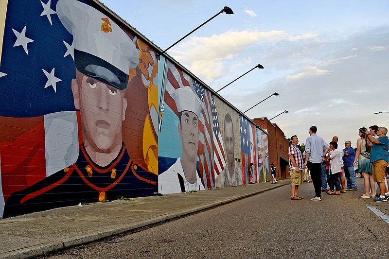 People gather on McCallie Avenue prior to the lighting of the mural, "For the Fallen."  Artist Kevin Bate created the work to memoralize the five serviceman killed on July 16, 2015.  