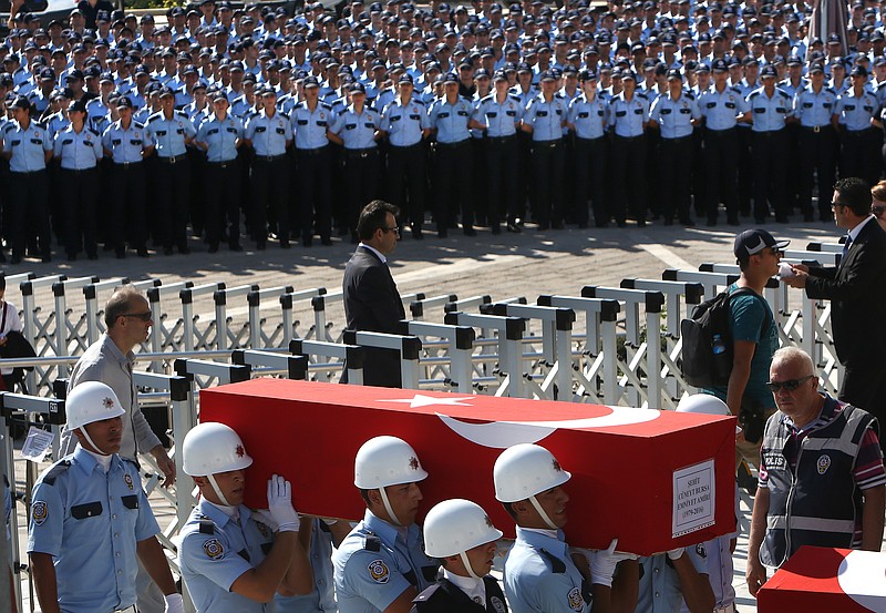 
              Turkish honor guards carry the coffin of a policeman killed Friday during the failed military coup, during a mass funeral in Ankara, Turkey, Sunday, July 17, 2016. The Turkish government accelerated its crackdown on alleged plotters of the failed coup against President Recep Tayyip Erdogan, with the justice minister saying Sunday that 6,000 people had been detained in the investigation, including three of the country's top generals and hundreds of soldiers. (AP Photo/Hussein Malla)
            