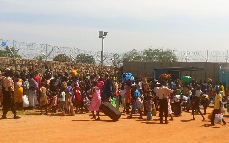 People with their luggage gather outside the United Nations World Food Programme gate in Juba, South Sudan, seeking shelter.