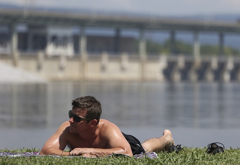Staff Photo by Dan Henry / The Chattanooga Times Free Press- 7/18/16. Blake Cash sunbathes at the Chickamauga Dam swimming area on Monday, July 18, 2016. 
