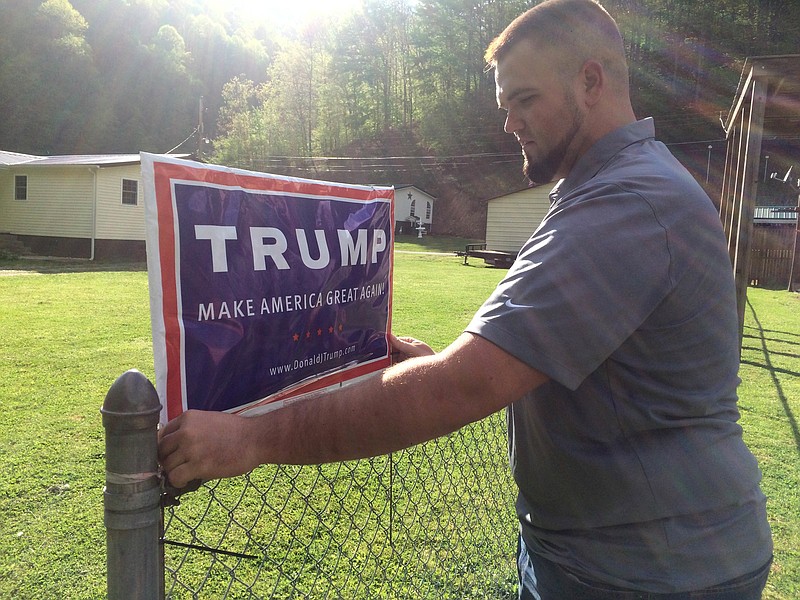 Billy Prater, 27, adjusts a Donald Trump sign on his fence in Beech Creek, W.Va., in Mingo County on April 28, 2016. Laid off from the mines, he had been out of work for more than a year. Now he works for the railroad, but the major customer is the collapsing coal industry so his work is unsteady. He was a registered Democrat from a family of diehard Democrats. But when he hung the Trump sign, his neighbors started calling and sending him messages, asking where he got it and how to get their own. "Everybody on this creek wants one," he said. "He's honest. He says thing that he probably shouldn't say. We respect that, because it means he's not buttering us up." (AP Photo/Claire Galofaro)
