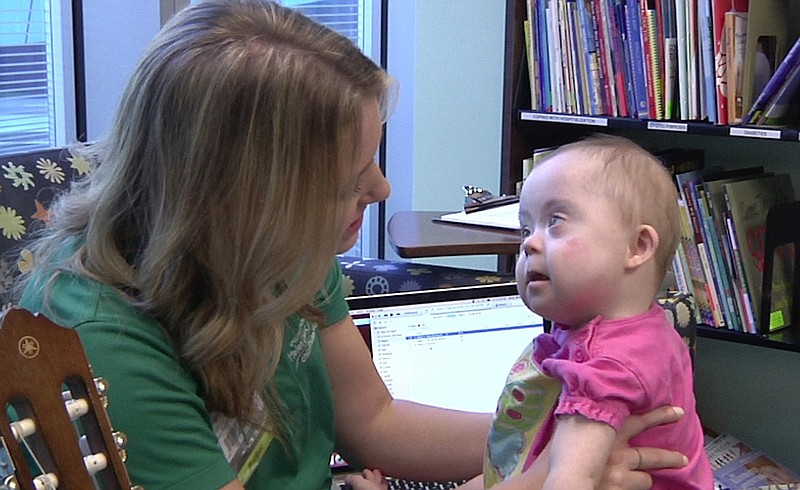 Bridget Sova, music therapist at Helen DeVos Children's Hospital in Grand Rapids, Mich., sings to Adalyn Betser at the hospital. (AP Photo/Mike Householder)