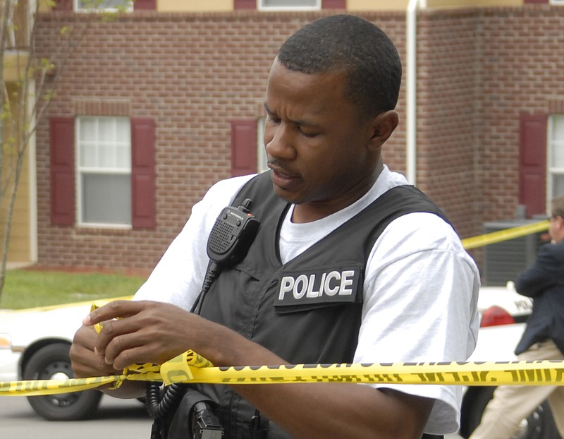 Robin Davenport ties up crime-scene tape at the scene of a 2008 shooting on Ryan Street in Chattanooga.