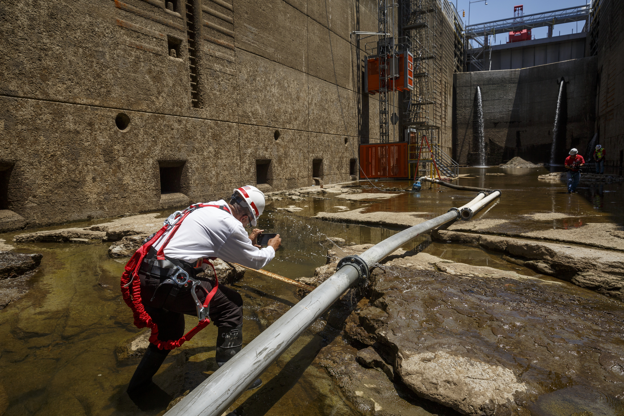 A TV reporter photographs a drainage pipe in the dewatered Chickamauga Lock at the Chickamauga Dam on Wednesday, July 20, 2016, in Chattanooga, Tenn. The lock is being dewatered for routine maintenance checks.