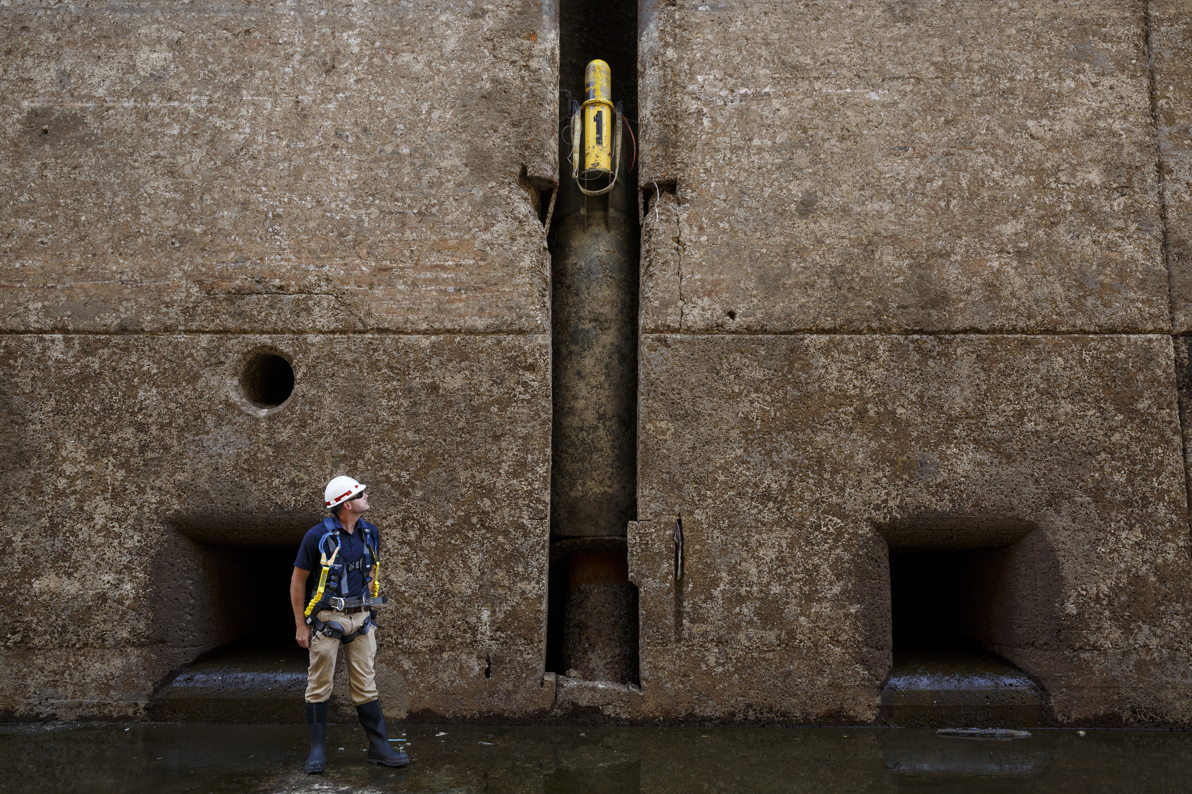 Civil engineer Mason Carter looks at a floating mooring bit, which is used to anchor boats, from inside the dewatered Chickamauga Lock at the Chickamauga Dam on Wednesday, July 20, 2016, in Chattanooga, Tenn. The lock is being dewatered for routine maintenance checks.