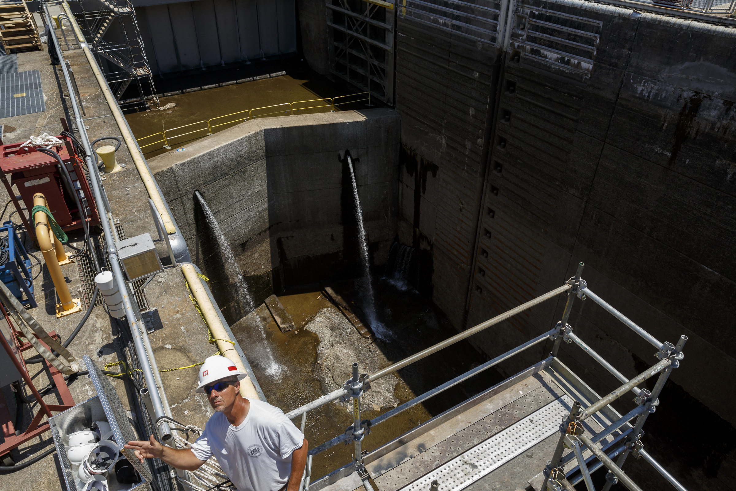 A worker directs a crane above the dewatered Chickamauga Lock at the Chickamauga Dam on Wednesday, July 20, 2016, in Chattanooga, Tenn. The lock is being dewatered for routine maintenance checks.