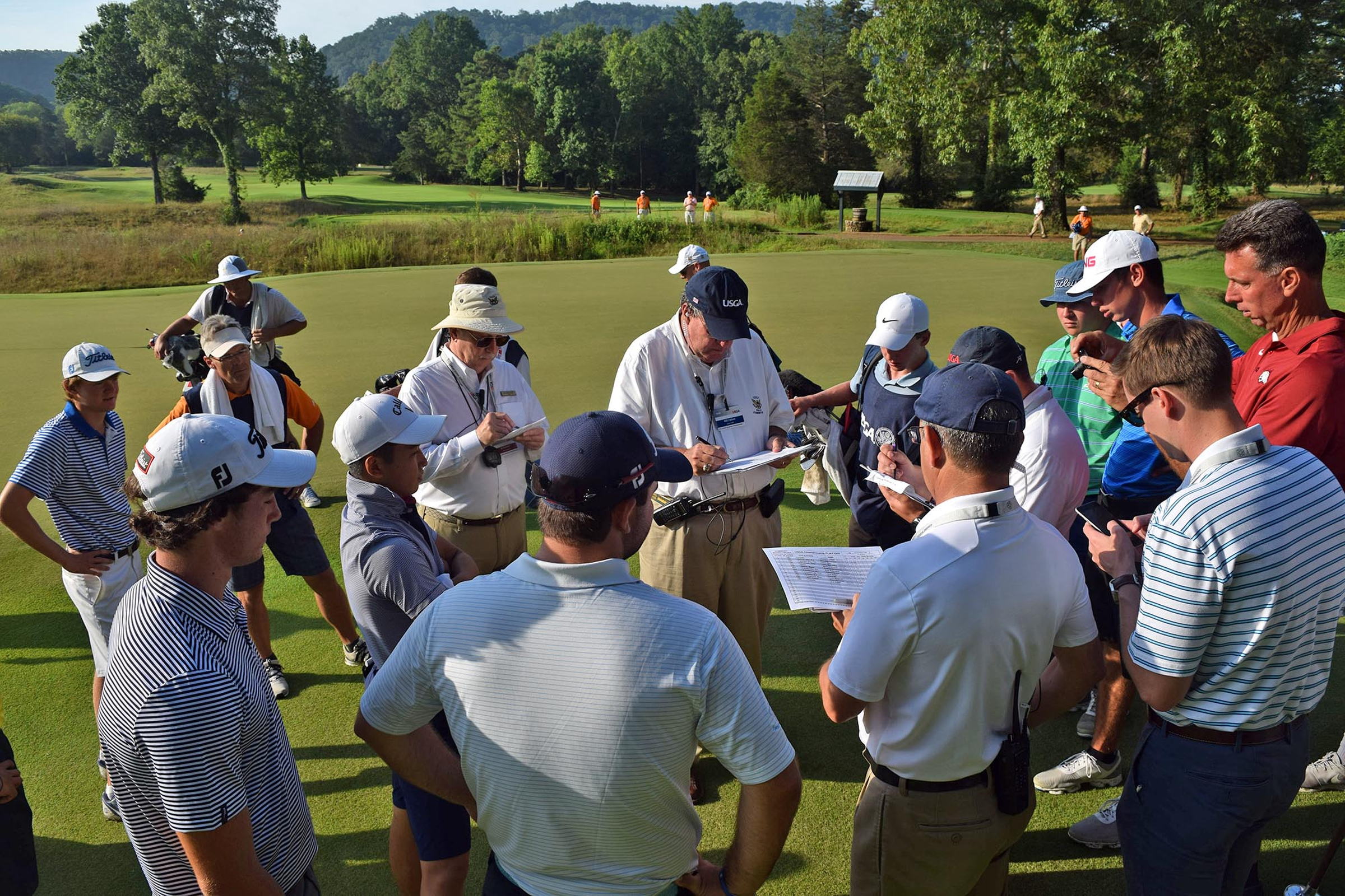 Players and caddies gather around USGA officials has it is determined which of the golfer in the playoffs will make it into the field of 64. The third day of the 69th U.S. Junior Amateur Championship was held at the Honors Course in Ooltewah, Tennessee, Wednesday July 20, 2016.